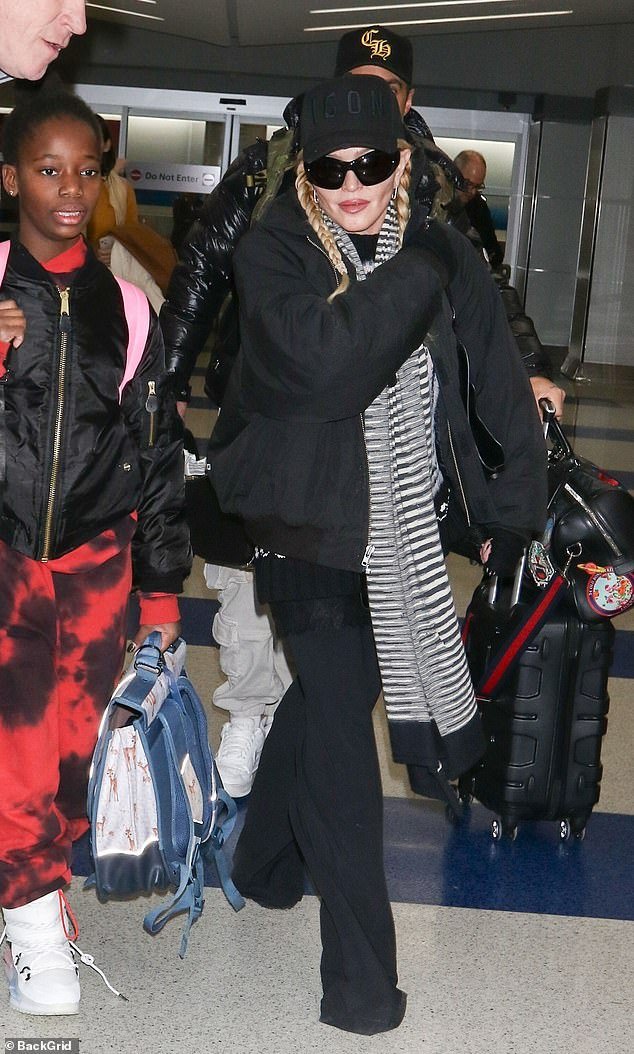 Madonna arrives in NYC with three of her six children, sporting an ‘ICON’ hat after wrapping up European leg of The Celebration Tour