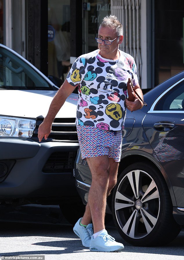 Andrew O’Keefe, TV host, seen in Sydney wearing a vibrant Mickey Mouse shirt and rainbow shorts as he goes about his day following meth charge dismissal