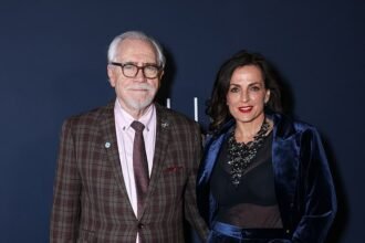 77-year-old Brian Cox looks stylish in plaid suit as he poses with his elegant wife Nicole Ansari-Cox, 55, at Dunhill & BSBP pre-BAFTA party.