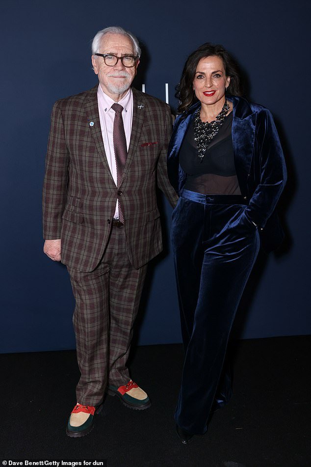 77-year-old Brian Cox looks stylish in plaid suit as he poses with his elegant wife Nicole Ansari-Cox, 55, at Dunhill & BSBP pre-BAFTA party.