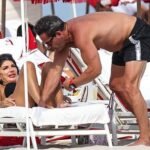 Teresa Giudice stuns in a bikini while showing PDA with shirtless husband Louie Ruelas on romantic beach day in Miami.