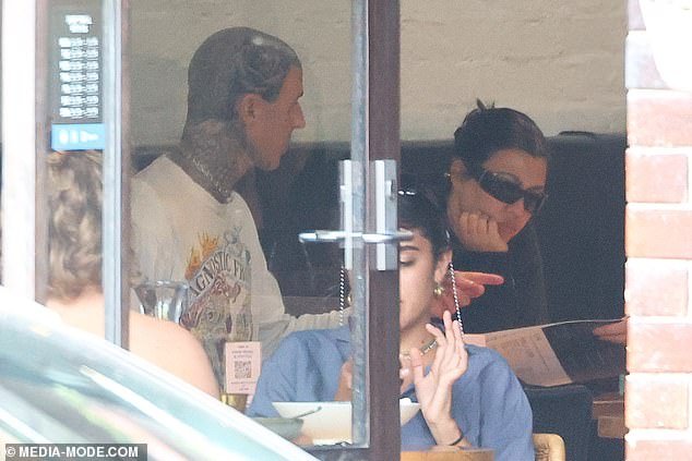 Kourtney Kardashian stuns in edgy black ensemble as she enjoys a meal with Travis Barker at Melbourne’s trendy vegetarian spot, the Vegie Bar.