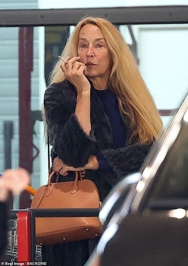 Jerry Hall, 67, arrives for Paris Fashion Week showcasing her natural beauty without makeup, casually puffing on a cigarette.