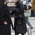 During Paris Fashion Week, Irina Shayk makes a fashionable statement in a sleek black leather trench coat and knee high boots.